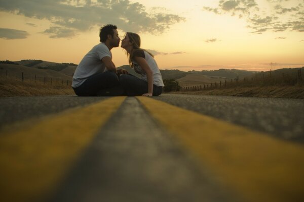 A couple of people are sitting on the road