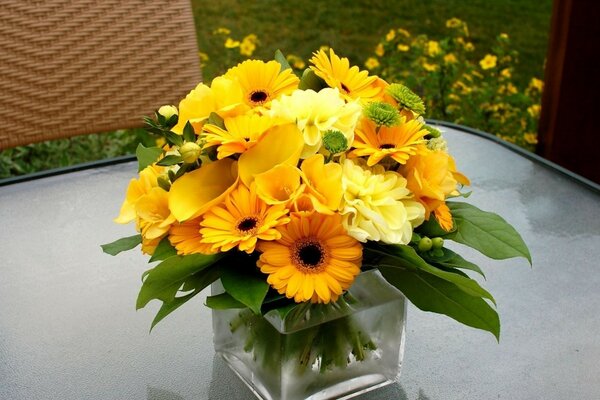 मेज पर एक फूलदान में पीले फूल