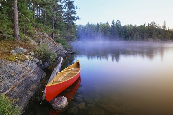 Red canoe in the reflection of the river