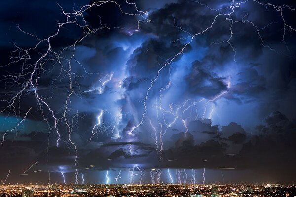 Truenos y relámpagos sobre las luces de la ciudad nocturna