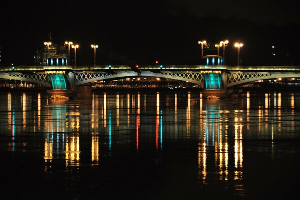 Beleuchtete Brücke, schöne Stadt, der Fluss ist groß, es ist angenehm zu reisen