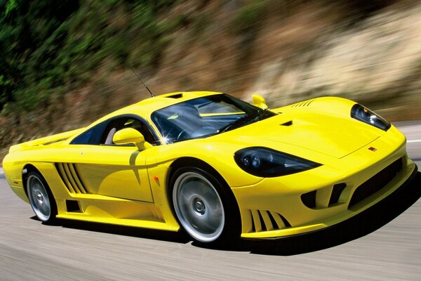 El coche de carreras amarillo vuela por la carretera