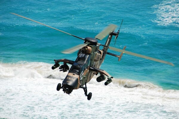 Helicóptero militar sobre o mar azul