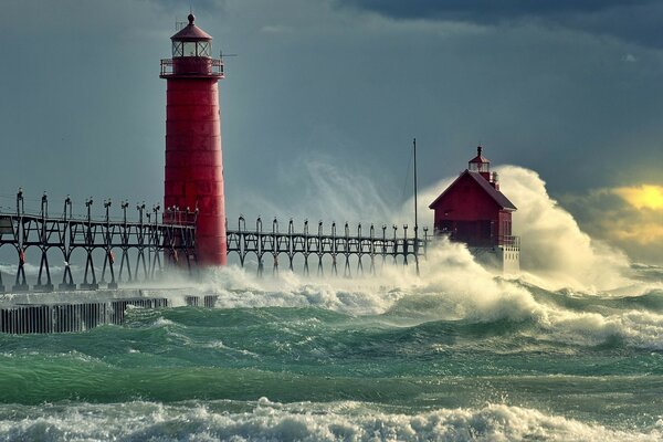 El faro rojo resiste el ataque de las olas del mar