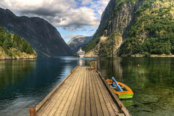 O barco está no cais. Água entre as montanhas