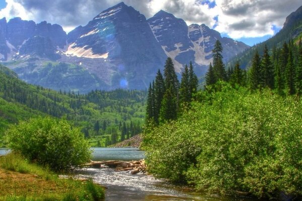 Paesaggio di montagne su uno sfondo di verde e acqua in estate