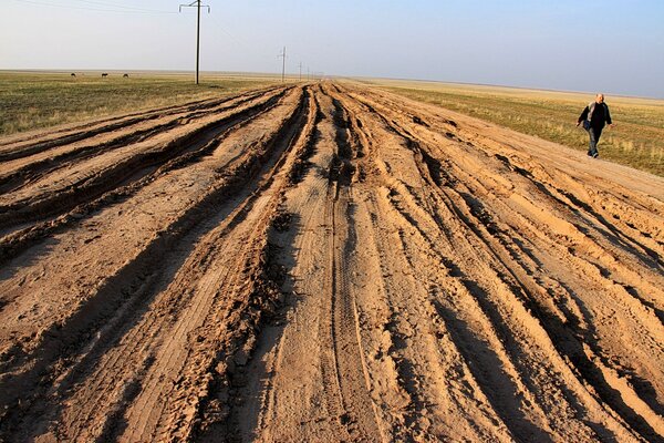 Estrada de areia que vai para longe. vem aí um homem