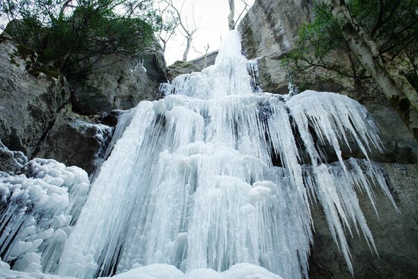 Cascada de invierno congelada en el fondo de las rocas