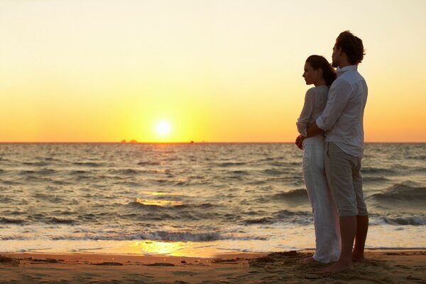 Pareja enamorada se encuentra con el amanecer del mar