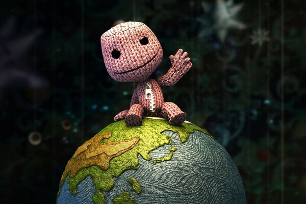 一个玩具编织的人在一个小地球仪