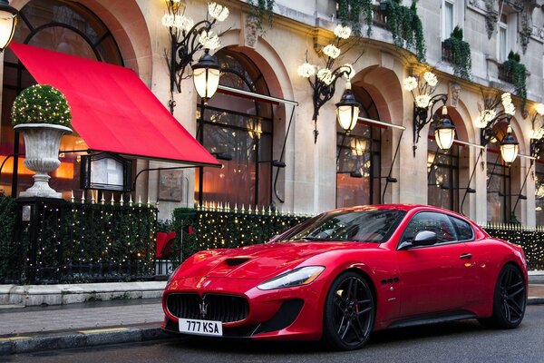 Maseratti rojo estacionado en el café