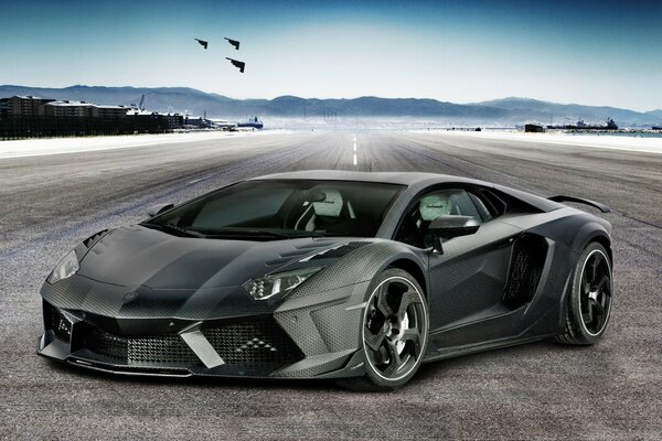 Gray racing car on the background of the sky and mountains