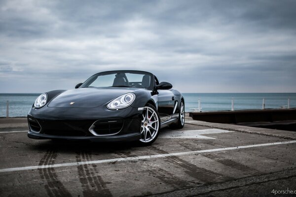 Porsche 911 negro junto al agua