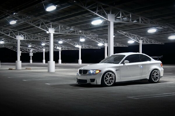 White car in the parking lot with lights