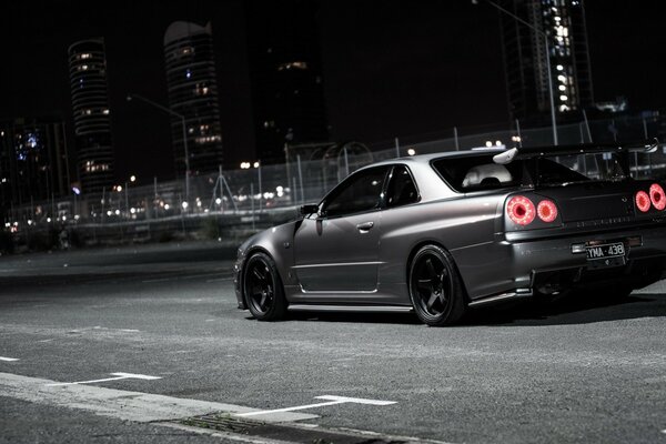 Coche negro corriendo por la ciudad de la noche