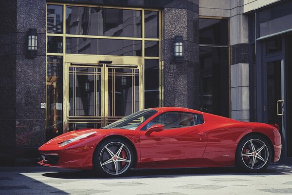 Ferrari Spyder vermelho de dois lugares em frente ao hotel