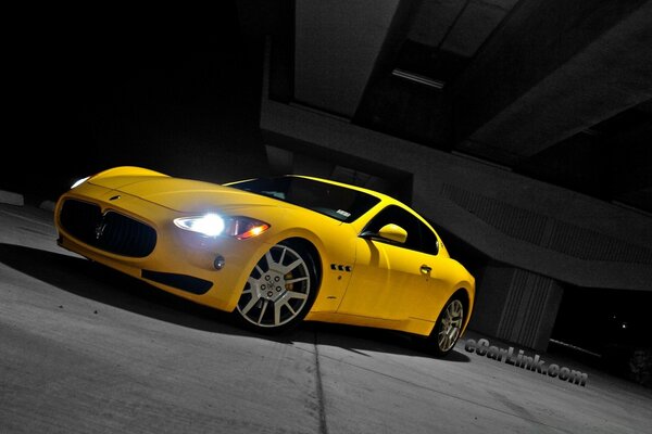 Coche de carreras amarillo con faros encendidos