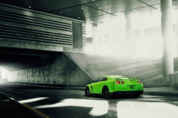 Un auto sportiva verde entra nel tunnel