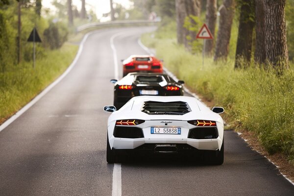 Drei Autos in einer Reihe fahren die Straße entlang