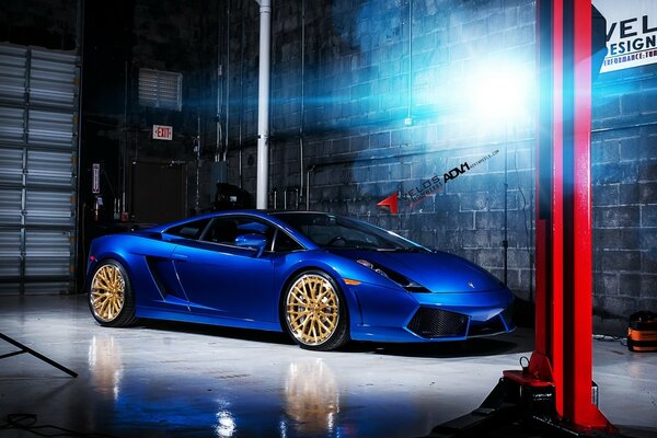 A sporty blue car in a grey hangar