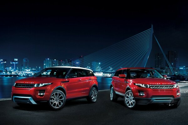 Red cars at night by the water