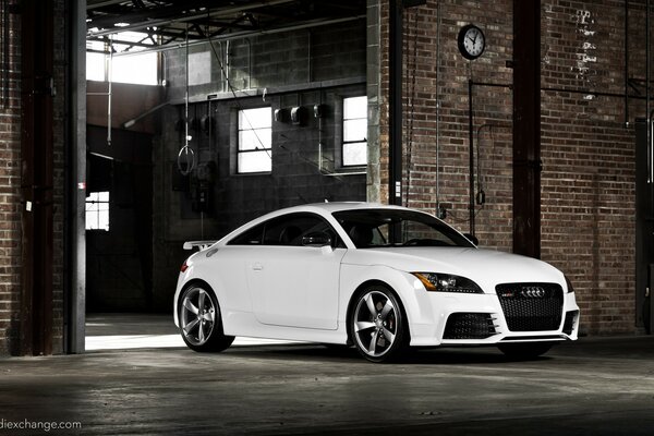 A white car in a brick garage