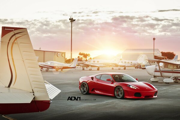 Roter Ferrari und weiße Flugzeuge