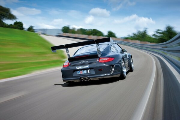 A black racing car slicing through the air on the track