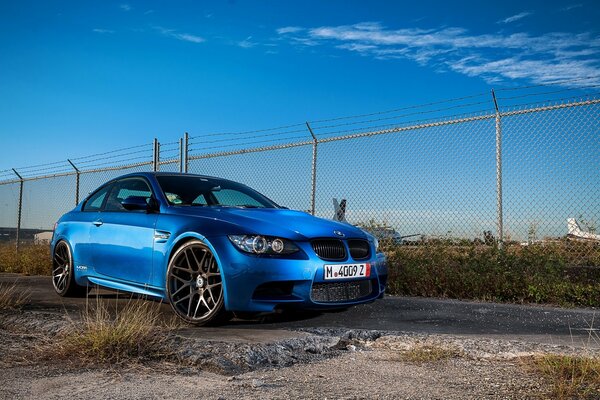 Blue racing car on blue sky background