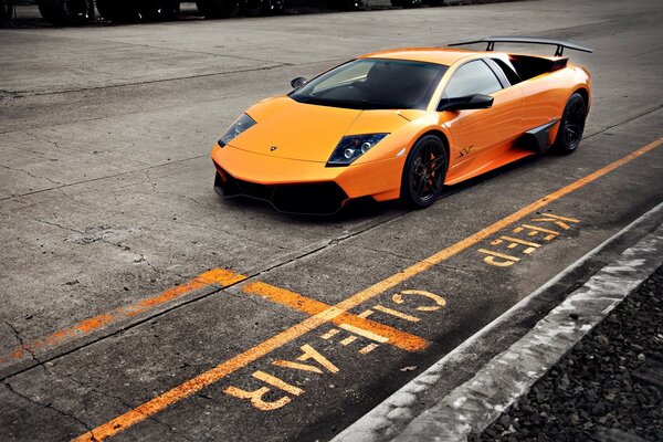 Orange car on gray asphalt