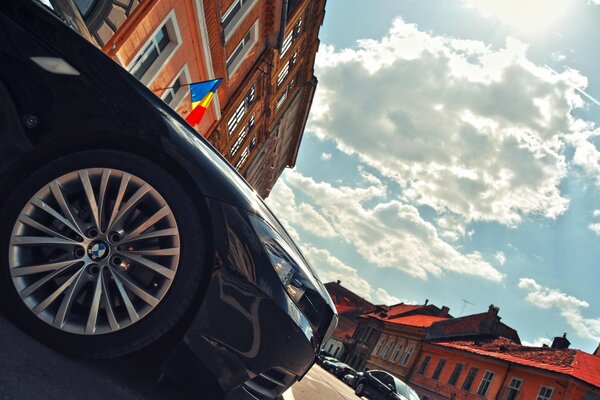 Part of a black car on a city background