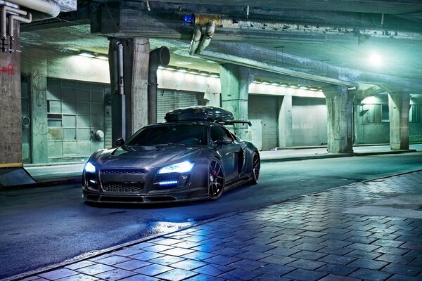 Car with lights on under the bridge