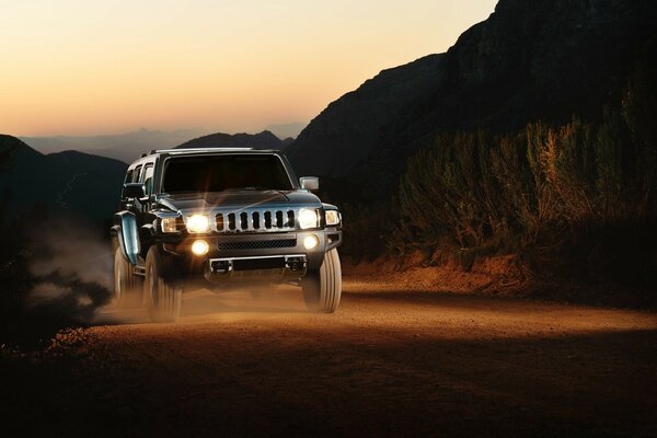 Moving jeep at sunset in the mountains