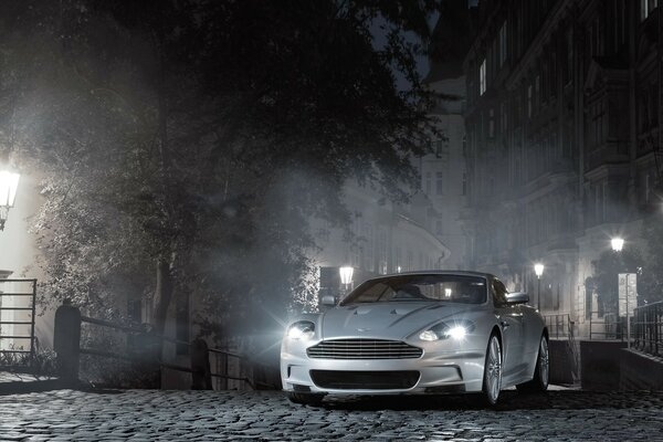 A gray car on a cobblestone road