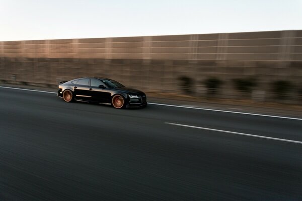 Coche negro conduciendo por la carretera