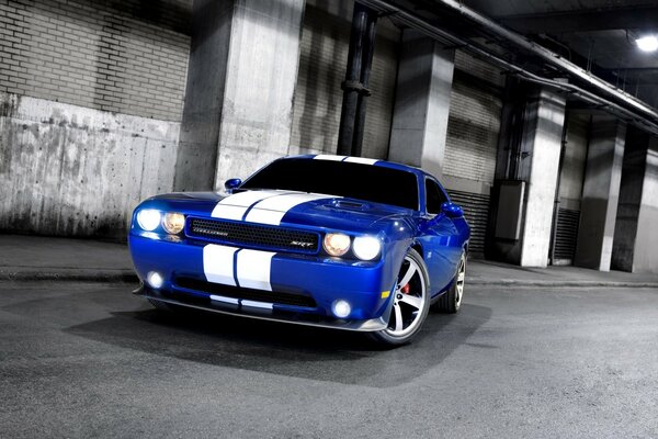 The sports car is parked against the background of garages