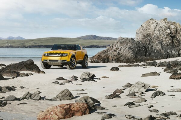 Yellow car on the background of the beach and rocks