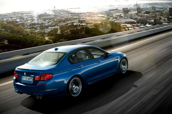 A blue car is racing along the highway