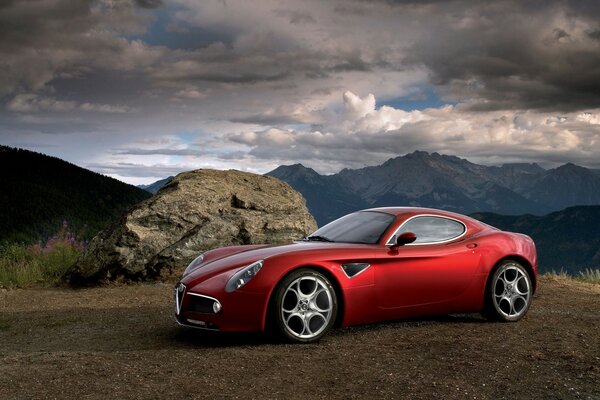 Rotes Auto auf dem Hintergrund der Berglandschaft