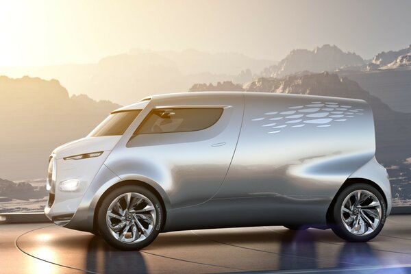 Futuristic car with chrome wheels on a mountain landscape background