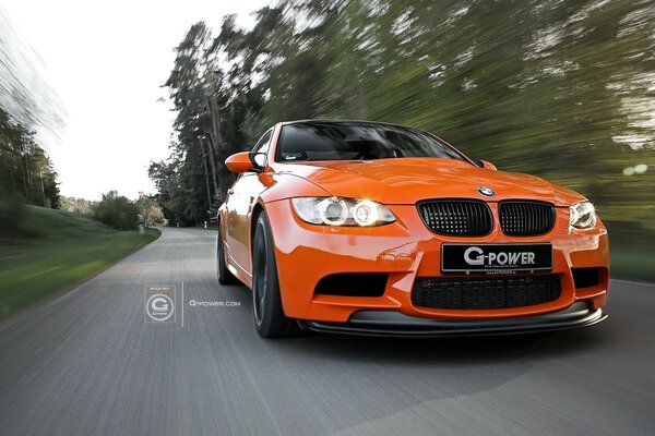 Coche naranja corre por carretera asfaltada