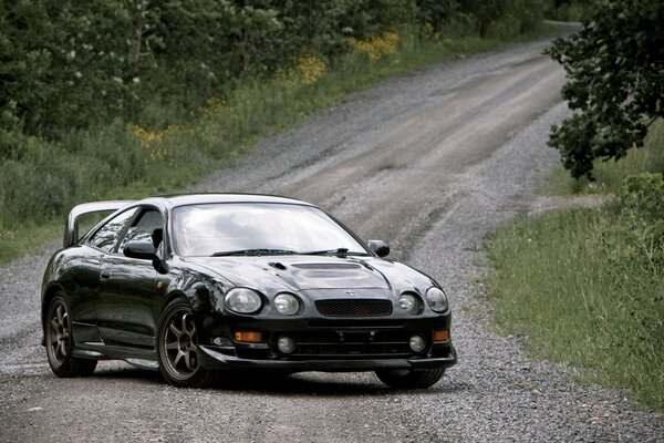 Der schwarze Toyota Celica T200 GT-four steht auf einem Feldweg