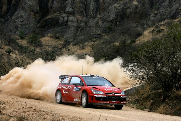 Voiture de course rouge sur la route de sable