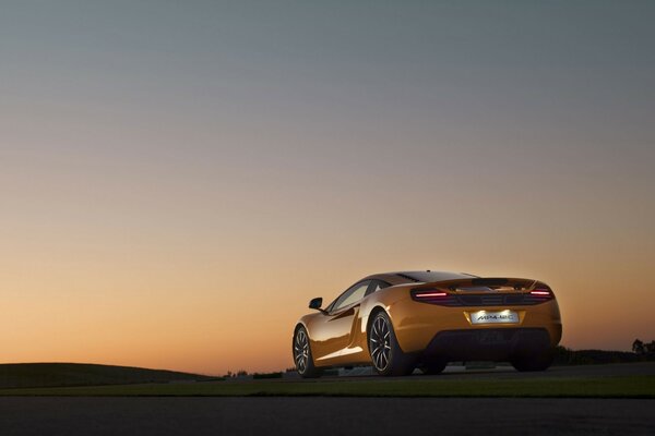 Coche amarillo en la parte trasera en medio de la puesta de sol