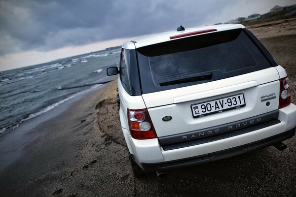 A white car conquers the seashore