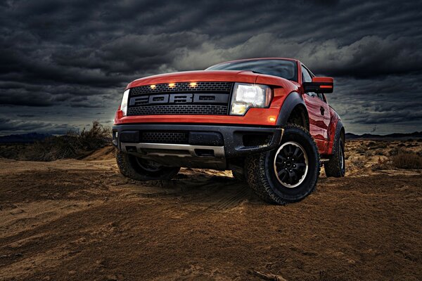 Bright red technological Ford car on the background of clouds