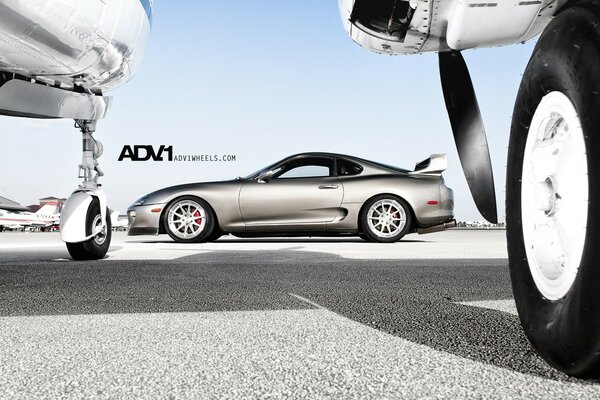 Voiture coupé argent Toyota Supra Mark IV, aérodrome et avions