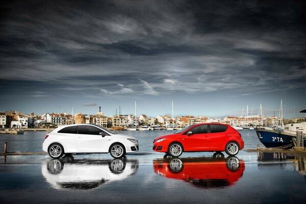 Staged photo of two cars by the water