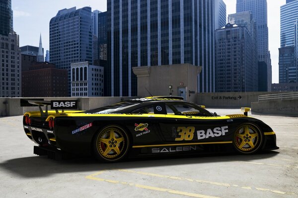 Coche de carreras deportivo negro en el fondo de edificios altos