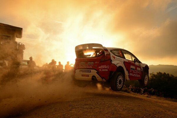 Racing car in the desert on the background of sunset